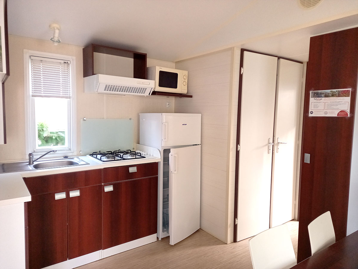 Mobil-home 2 chambres -Camping sur la côte vendéenne- Coin cuisine équipée avec réfrigérateur-freezer micro-ondes et plaque gaz